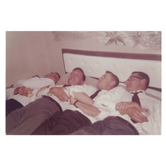 A group of guys lying on a bed